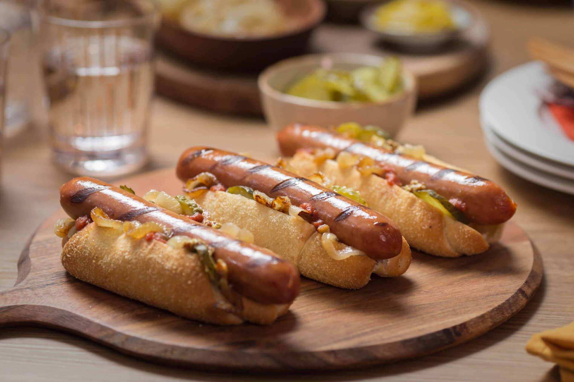 loaded bratwursts with caramelised onions sitting on a chopping board