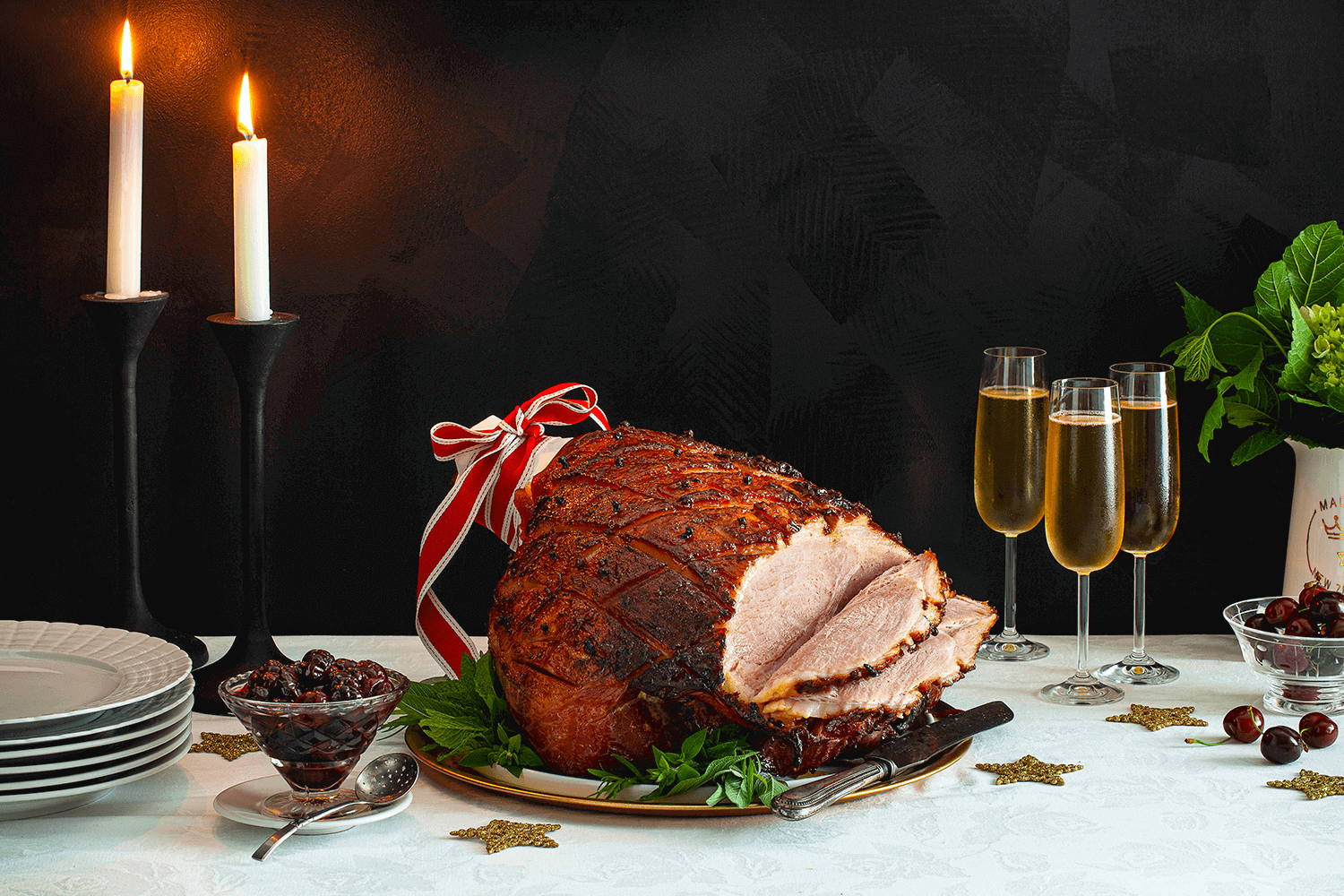 Cherry Rum Glazed Ham Recipe beautifully displayed at a fancy dinner table with champagne glasses