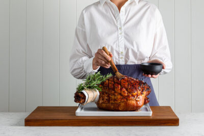 woman showing you how to glaze a Ham